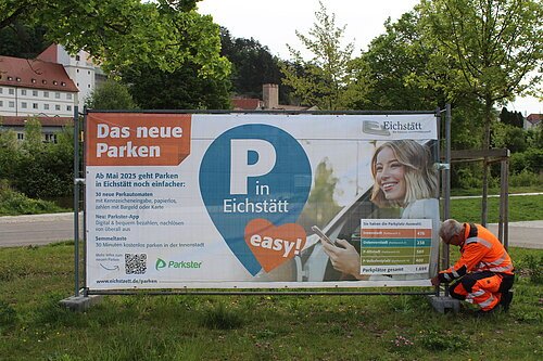 Informieren über den Start des neuen Park-Systems: Sechs große Informationsbanner – hier montiert am Parkplatz Altstadt von Andreas Weidenhiller vom städtischen Bauhof. Ergänzt werden sie von 23 Info-Schildern rund um die Parkautomaten in der Innenstadt. Fotos: Cherevko/Stadt Eichstätt