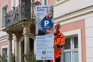 Informieren über den Start des neuen Park-Systems: Sechs große Informationsbanner – hier montiert am Parkplatz Altstadt von Andreas Weidenhiller vom städtischen Bauhof. Ergänzt werden sie von 23 Info-Schildern rund um die Parkautomaten in der Innenstadt. Fotos: Cherevko/Stadt Eichstätt