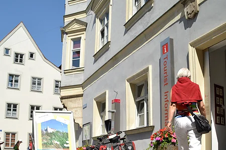 Tourist-Information mit Frau und Fahrräder, Eingang mit Aufsteller