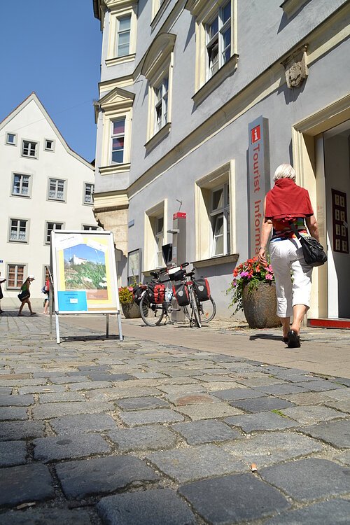 Tourist-Information Eingang mit Aufsteller Tourist-Information mit Frau und Fahrräder, Eingang mit Aufsteller