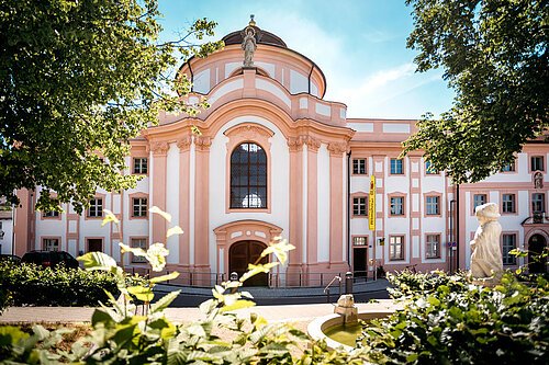 Informationszentrum Naturpark Altmühltal Barockgebäude mit großer Fensterfront, Statue auf dem Dach und Springbrunnen im Vordergrund bei Sonnenschein