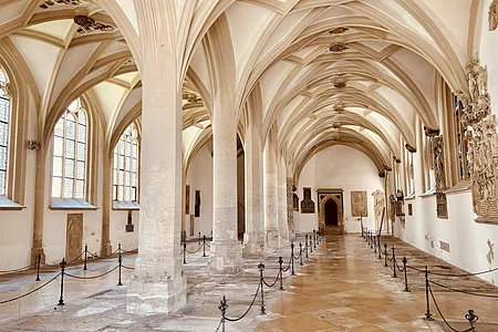 Ein von Säulen gestütztes Gewölbe. Ein abgesperrter Weg führt nach hinten durch das Gewölbe