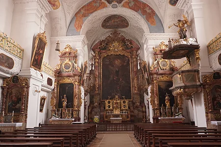 Innenraum einer Kirche mit bemalten Decken, Altären, Holzbankreihen und vergoldeten Verzierungen