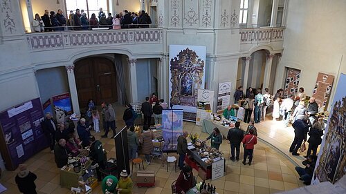 Saisonstart im Infozentrum Naturpark Altmühltal Innenraum mit Ständen und Menschen auf einer Messe oder Ausstellung in einem historischen Gebäude